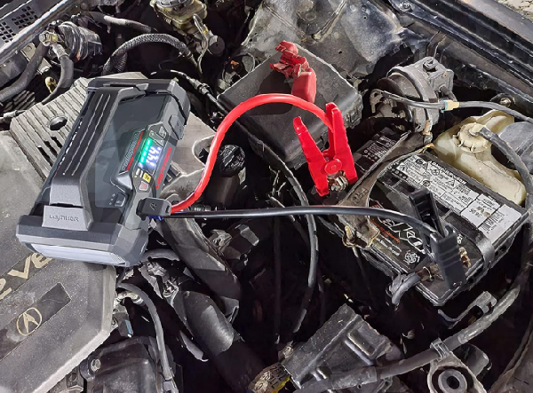Jump starter connected to car battery for recharging.